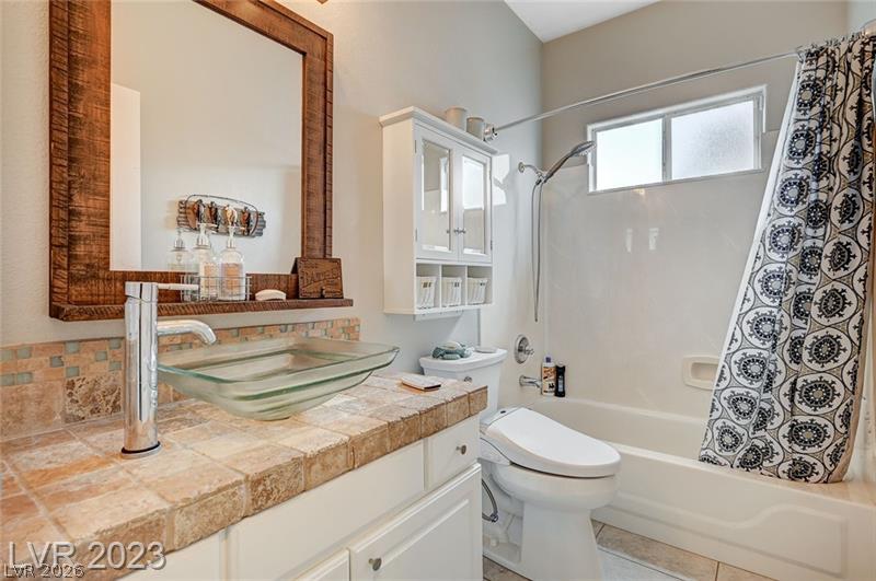 987 Cutter Street Henderson, NV 89011 - Photo 14 of 17 A stylish vanity with a vessel sink and rustic-framed mirror anchors this well-appointed bath.