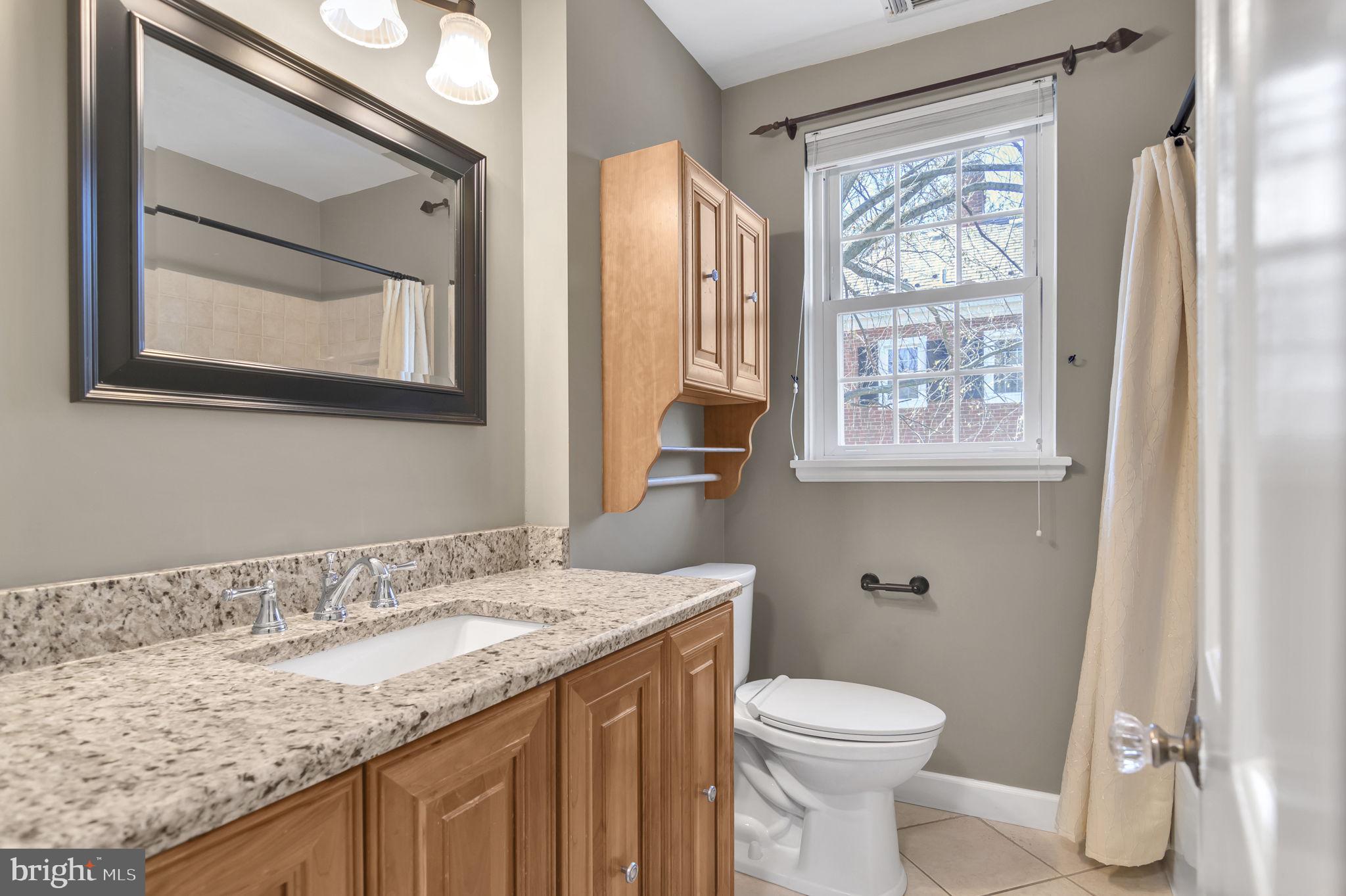 4237 32nd Road South Arlington, VA 22206 - Photo 34 of 49 a bathroom with a granite countertop sink toilet and a mirror