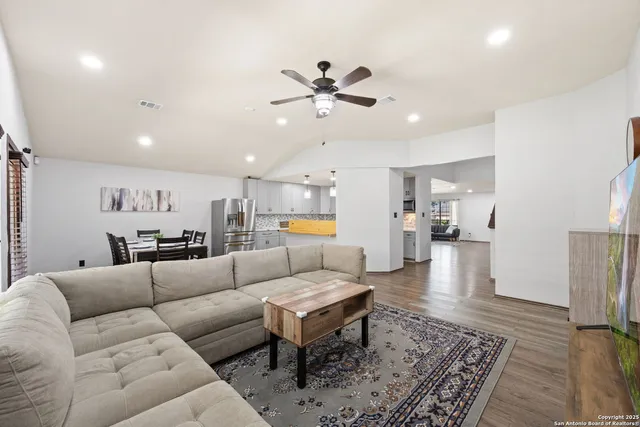 a living room with furniture and kitchen view