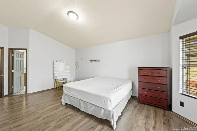 a spacious bedroom with a bed and a dresser