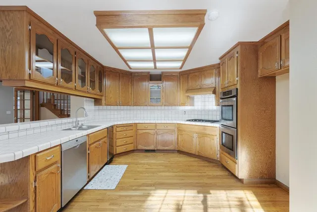 a large kitchen with stainless steel appliances granite countertop a refrigerator and a sink