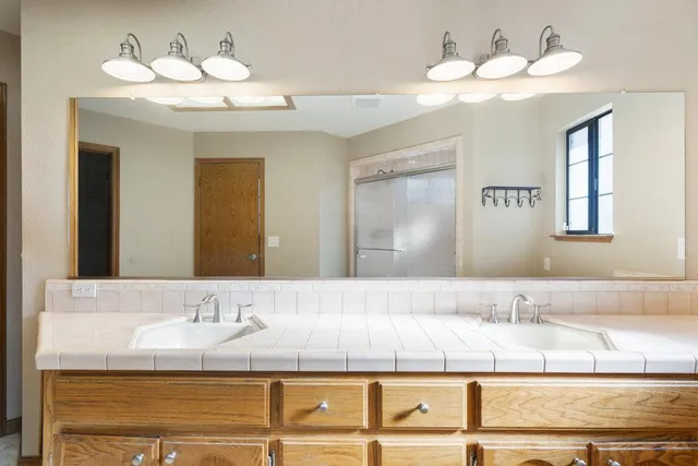 a bathroom with a sink a mirror and a lamp