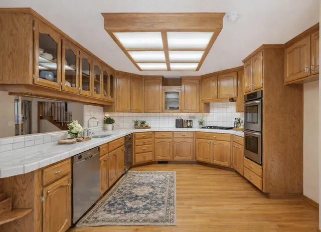 a kitchen with stainless steel appliances granite countertop a sink and cabinets
