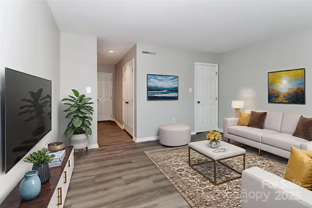 a living room with furniture potted plant and wooden floor