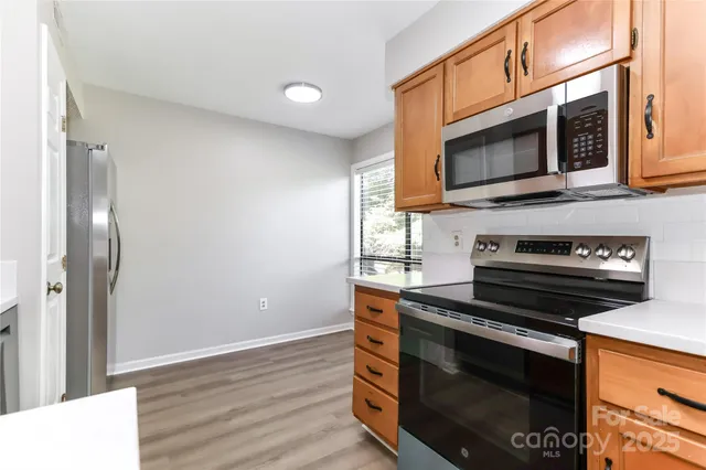 a kitchen with stainless steel appliances a stove microwave and sink
