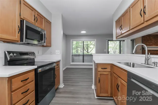 a kitchen with stainless steel appliances granite countertop a stove microwave and sink