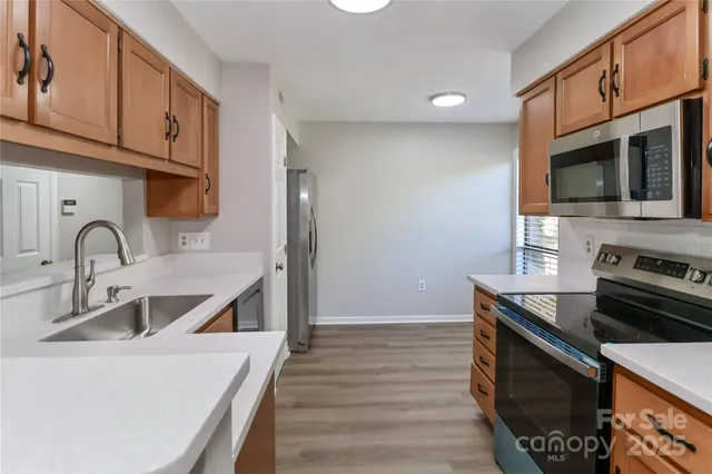 a kitchen with stainless steel appliances granite countertop a stove a sink and a microwave