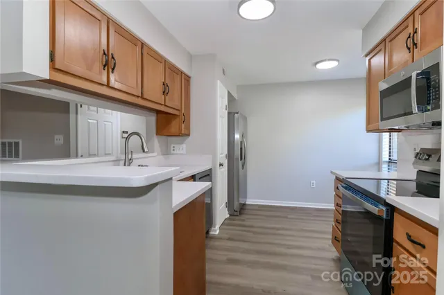 a kitchen with stainless steel appliances granite countertop a sink and cabinets