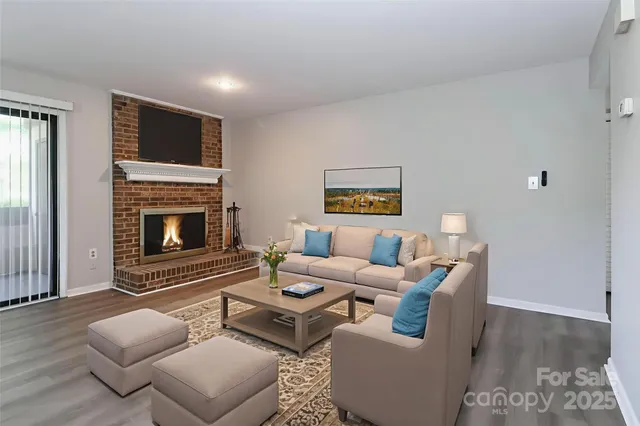 a living room with furniture a fireplace and a flat screen tv