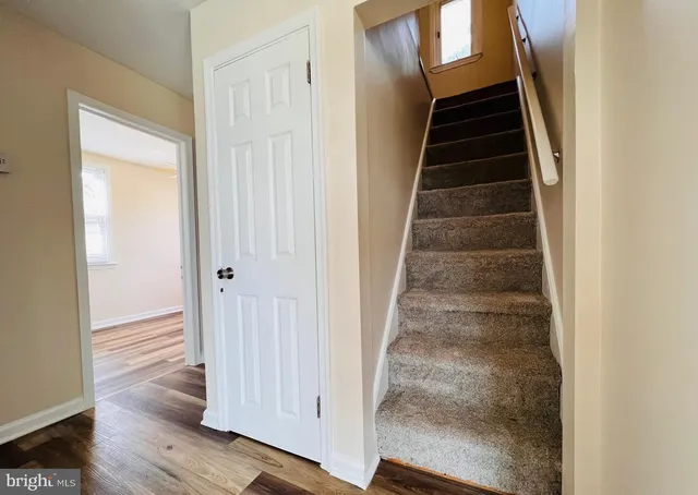 a view of a hallway with wooden floor and entryway