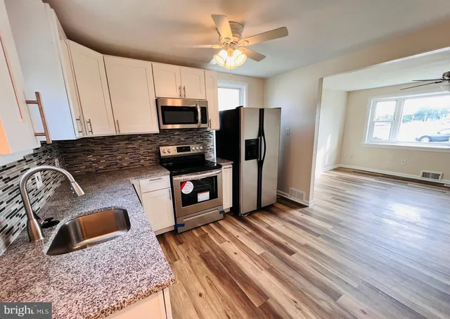 a kitchen with stainless steel appliances granite countertop a stove a sink dishwasher a microwave oven with granite countertops and cabinets