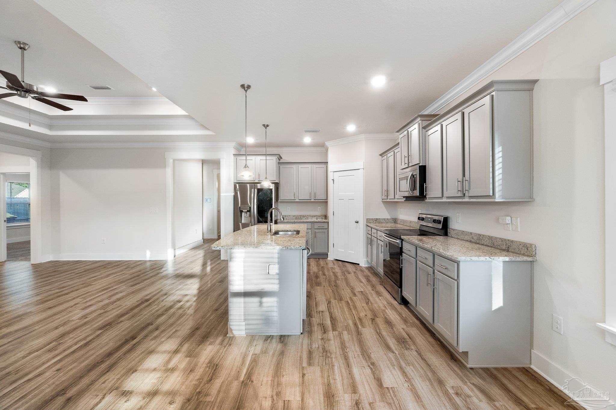 4527 Jude Way Pace, FL 32571 - Photo 12 of 38 a kitchen with stainless steel appliances kitchen island granite countertop a sink cabinets and wooden floor