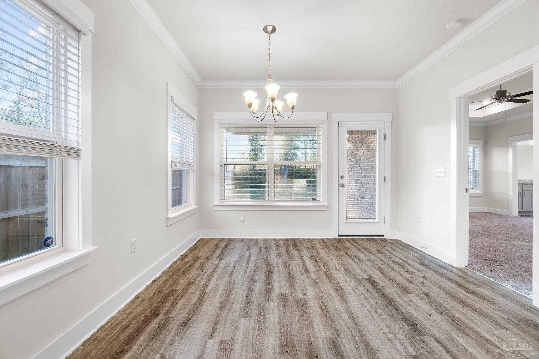 4527 Jude Way Pace, FL 32571 - Photo 14 of 38 a view of an empty room with wooden floor and a window