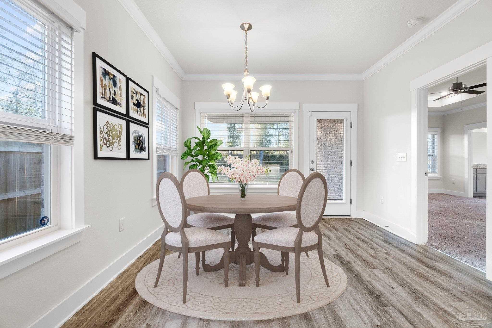 4527 Jude Way Pace, FL 32571 - Photo 15 of 38 a dining room with furniture a potted plant and wooden floor