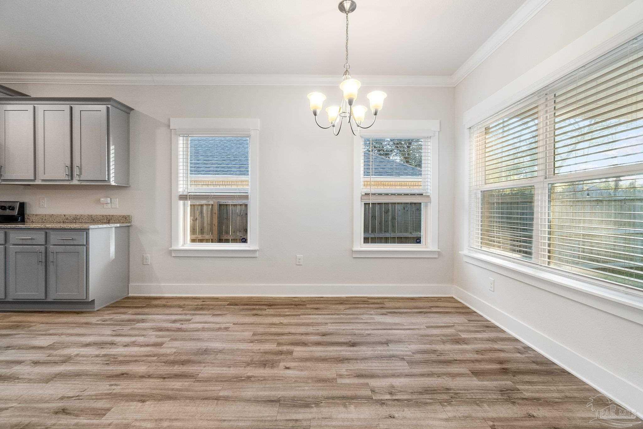 4527 Jude Way Pace, FL 32571 - Photo 16 of 38 a view of an empty room with a window and wooden floor