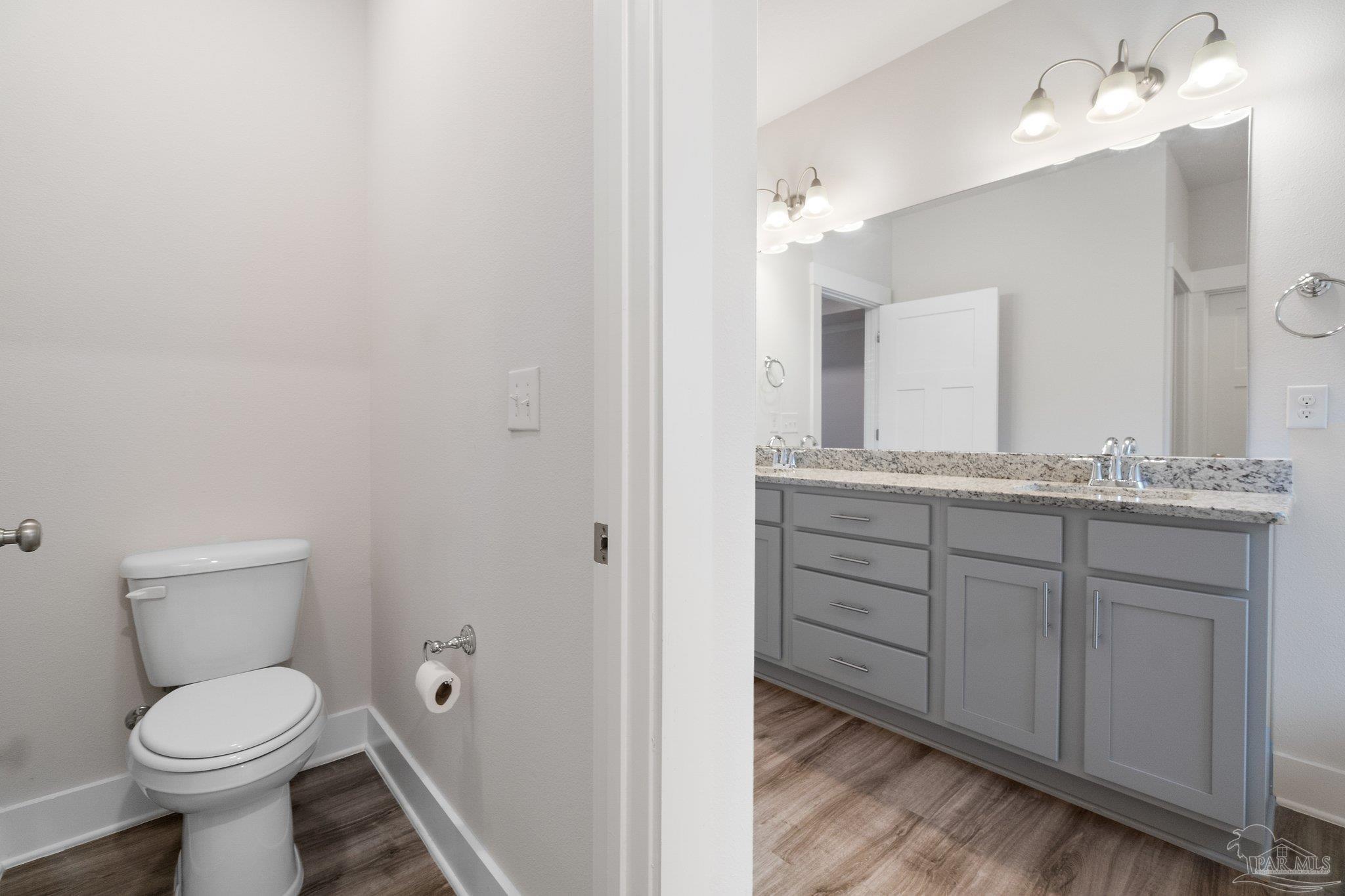 4527 Jude Way Pace, FL 32571 - Photo 24 of 38 a bathroom with a granite countertop toilet sink and mirror