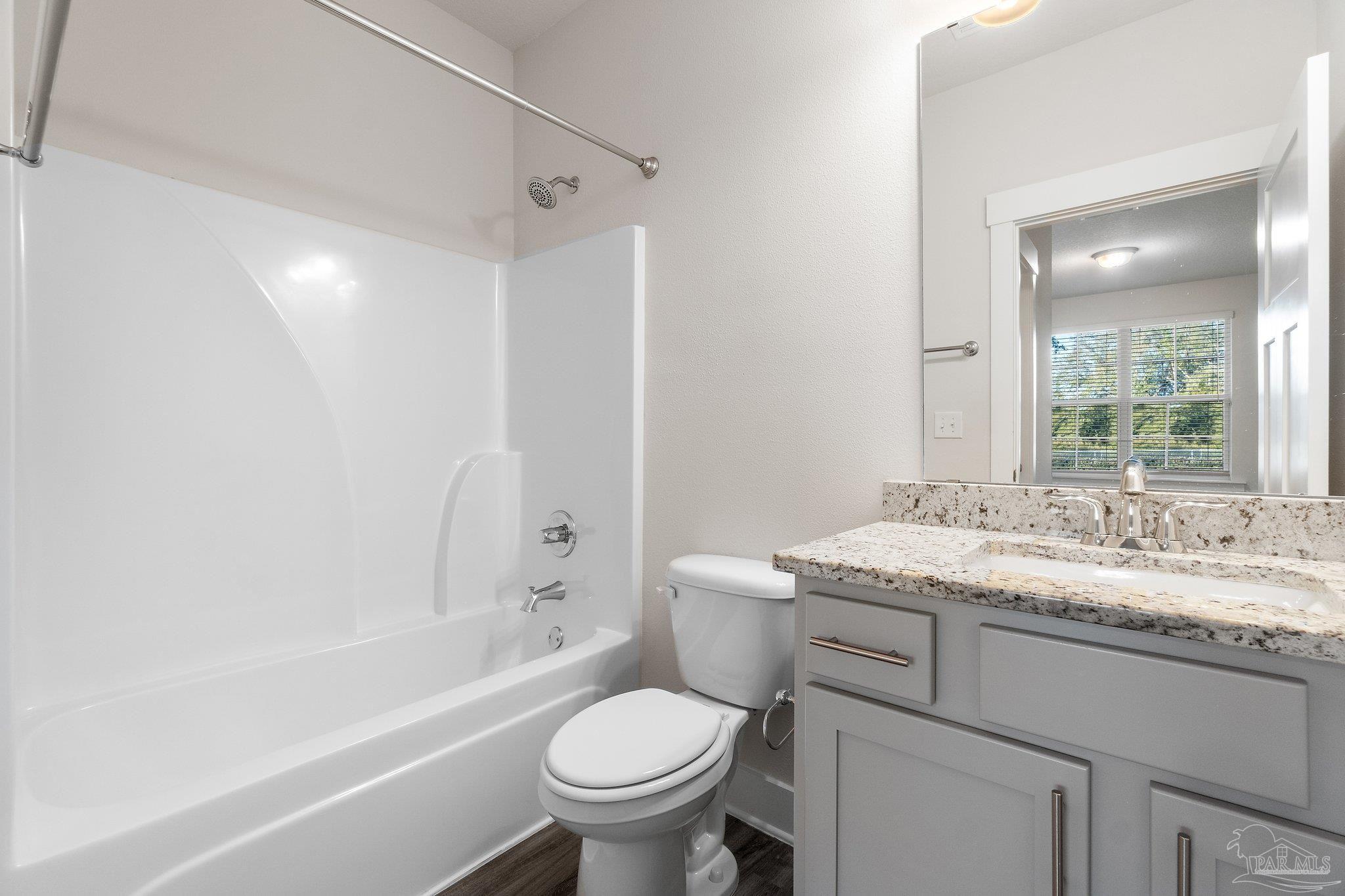 4527 Jude Way Pace, FL 32571 - Photo 33 of 38 a bathroom with a granite countertop toilet a sink and a bathtub