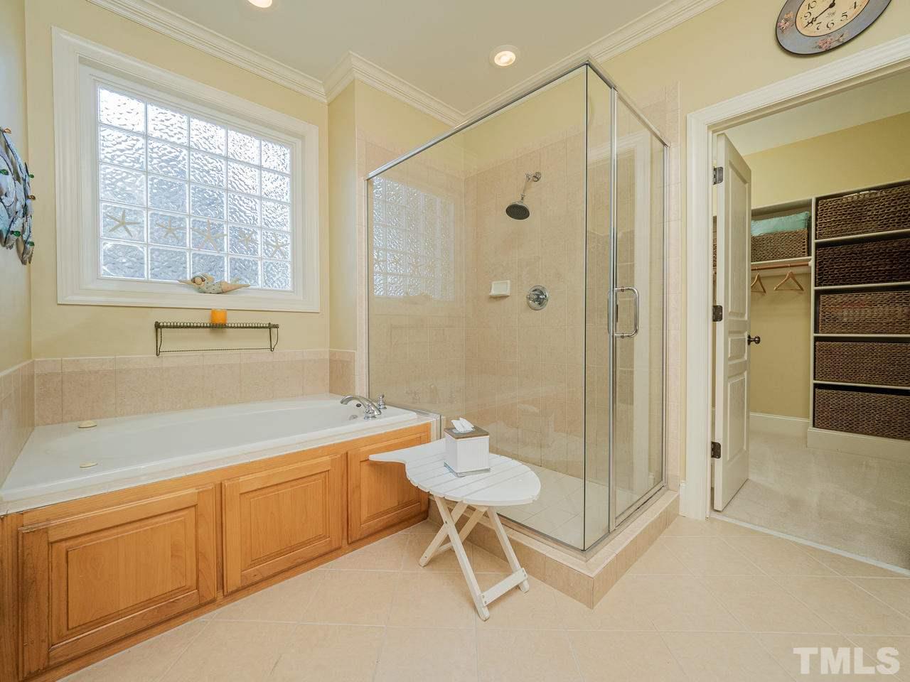 1217 Colonial Club Road Wake Forest, NC 27587 - Photo 14 of 30 Sunny owner suite bathroom with a large whirlpool tub and separate shower.