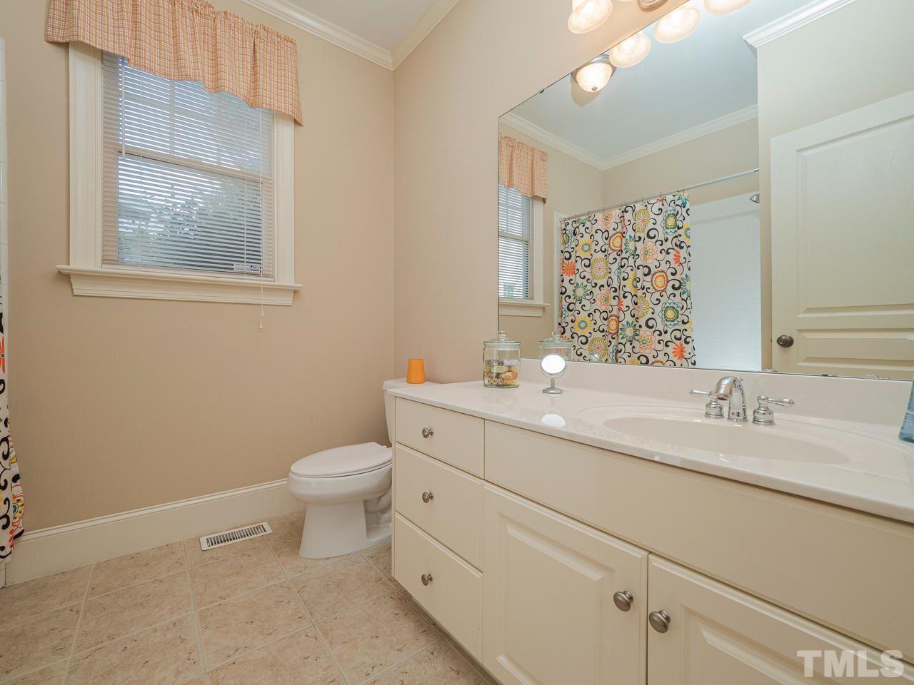 1217 Colonial Club Road Wake Forest, NC 27587 - Photo 18 of 30 Bathroom with a window, ceramic tub and tile surround.