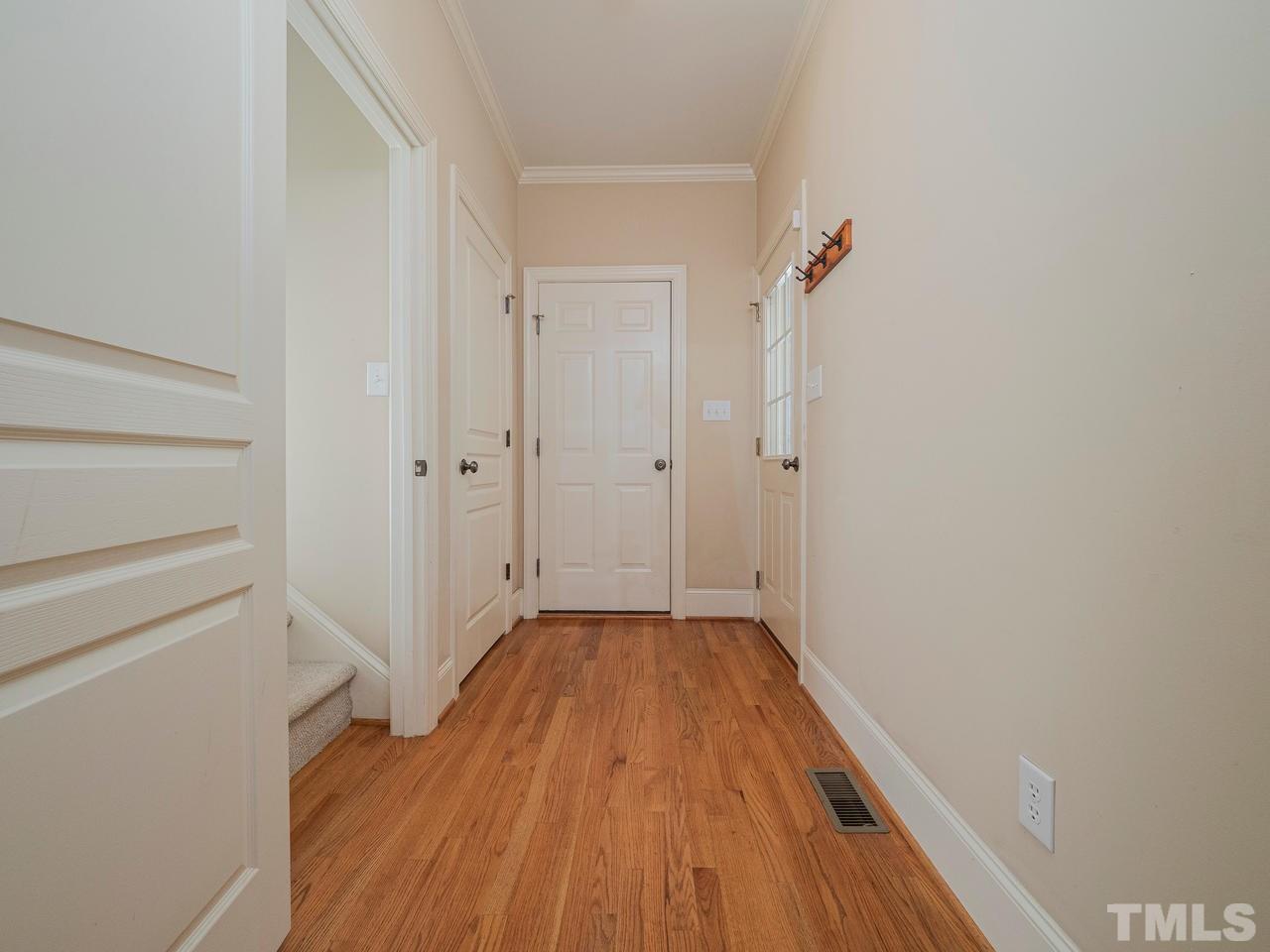 1217 Colonial Club Road Wake Forest, NC 27587 - Photo 20 of 30 This is the hallway to bring your groceries in from the garage. Or slip out the side door to the front rocking chair porch. And also the route to the staircase to the private bonus room on the 2nd level.