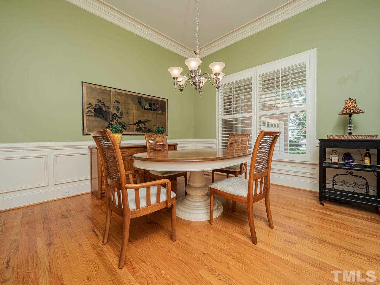 1217 Colonial Club Road Wake Forest, NC 27587 - Photo 6 of 30 Open dining room with crown molding, chair rail and plantation shutters.