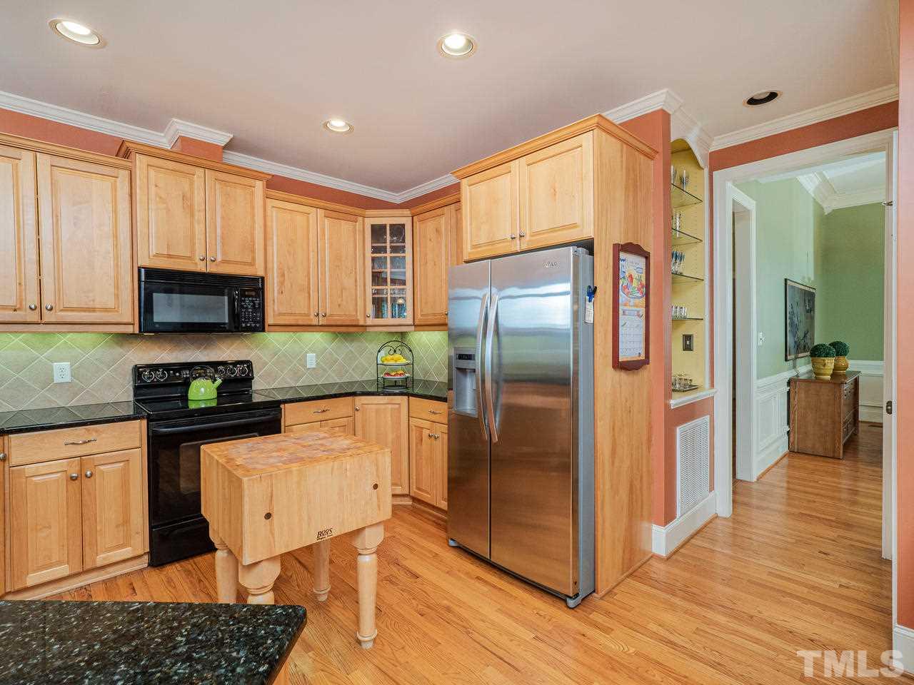 1217 Colonial Club Road Wake Forest, NC 27587 - Photo 10 of 30 Butcher block island, granite counter tops, maple cabinetry, and recessed lighting.