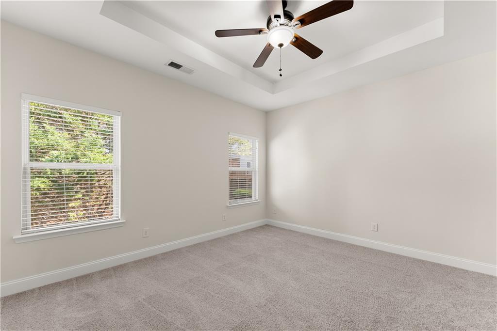 1203 Firethorne Pass Cumming, GA 30040 - Photo 16 of 37 en empty room with windows and ceiling fan