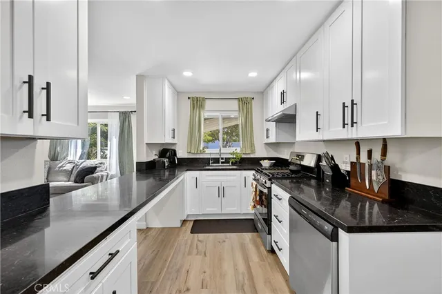 a kitchen with a sink a stove and cabinets