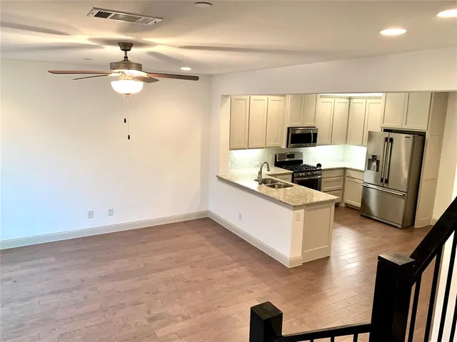 a kitchen with stainless steel appliances granite countertop a refrigerator and a stove top oven