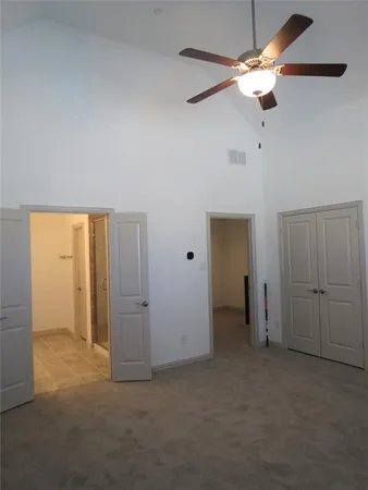 an empty room with closet and a chandelier fan
