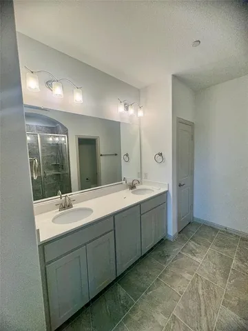 a bathroom with a double vanity sink mirror and bathtub