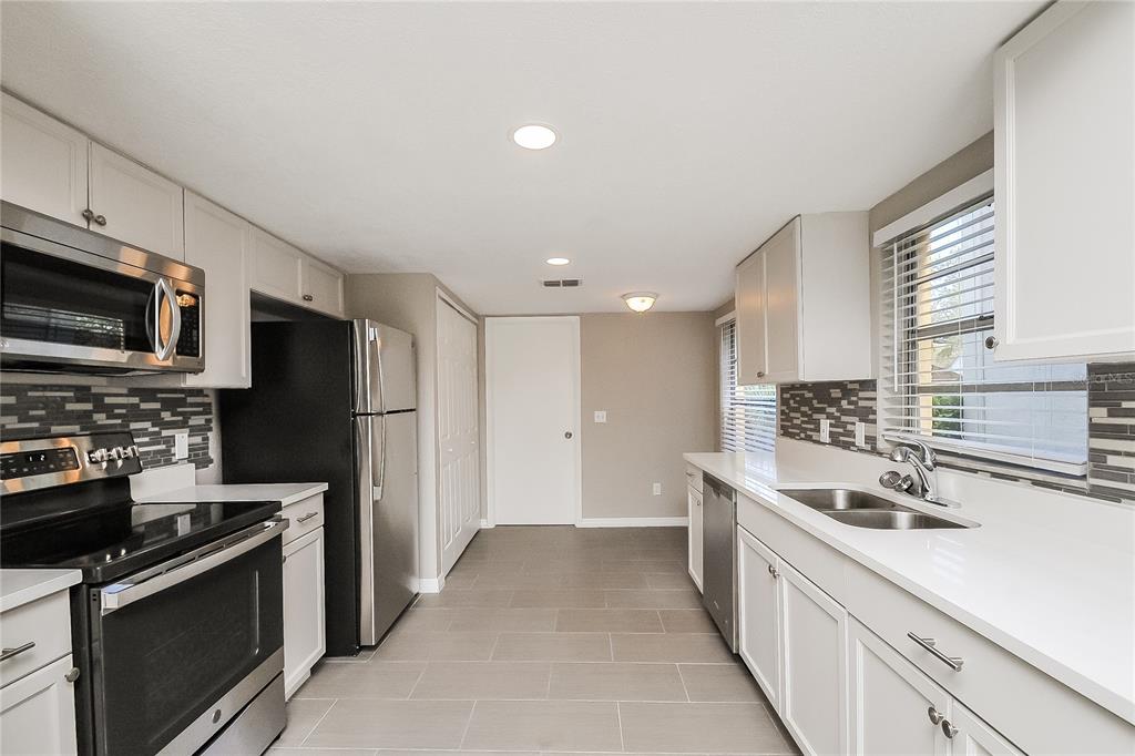 1625 Crossridge Drive Brandon, FL 33510 - Photo 4 of 16 a kitchen with stainless steel appliances a sink stove microwave and refrigerator