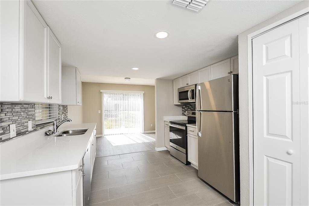 1625 Crossridge Drive Brandon, FL 33510 - Photo 5 of 16 a kitchen with a refrigerator sink stove and cabinets