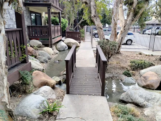 a view of swimming pool with lawn chairs and plants