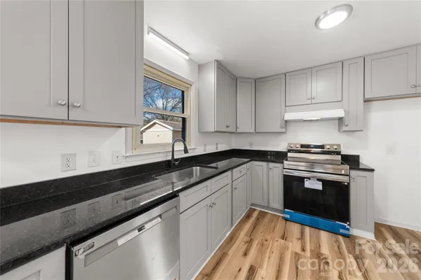 a kitchen with granite countertop cabinets stainless steel appliances and a sink