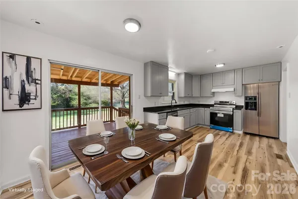 a open dining room with furniture a large window and kitchen view