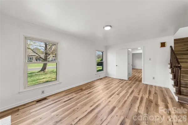 a view of empty room with wooden floor and window