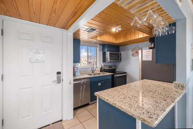 a kitchen with granite countertop a sink a stove and a wooden cabinets