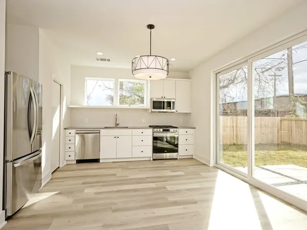 a kitchen with stainless steel appliances a stove sink and refrigerator