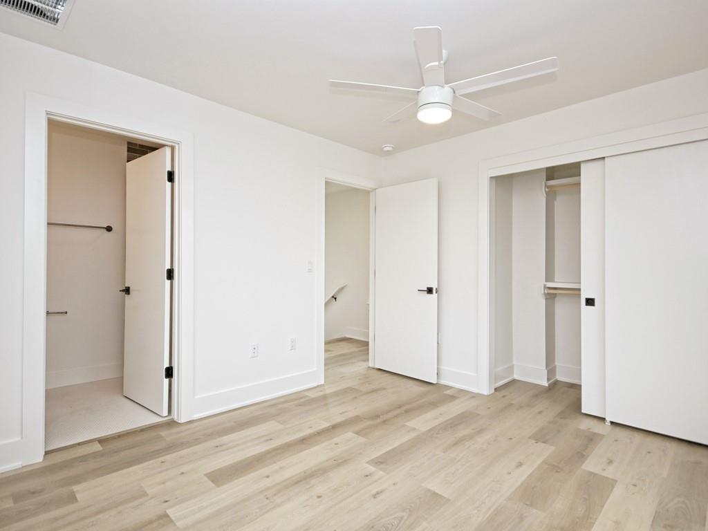 1116 Atkinson Road Austin, TX 78752 - Photo 17 of 27 Unfurnished bedroom featuring ensuite bath, light wood-style floors, a ceiling fan, and a closet