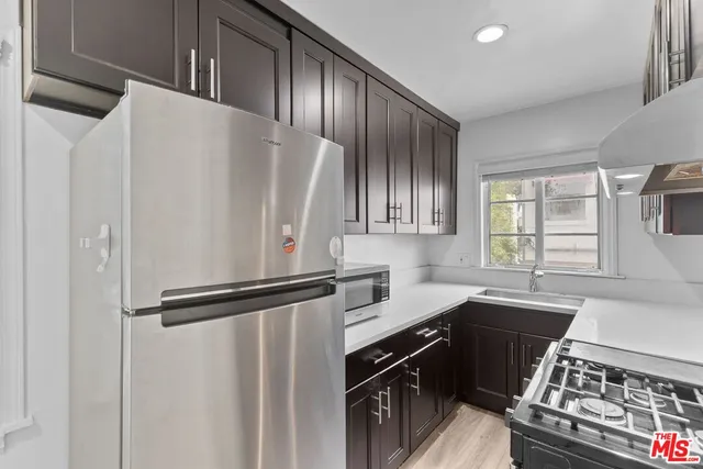 a kitchen with granite countertop a refrigerator and a sink