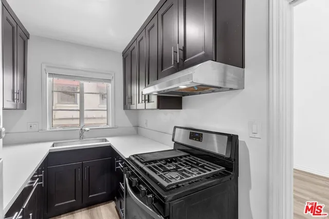 a kitchen with granite countertop a stove and a sink