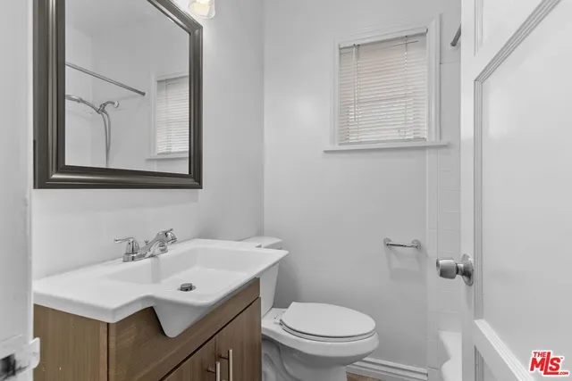 a bathroom with a sink toilet and a mirror