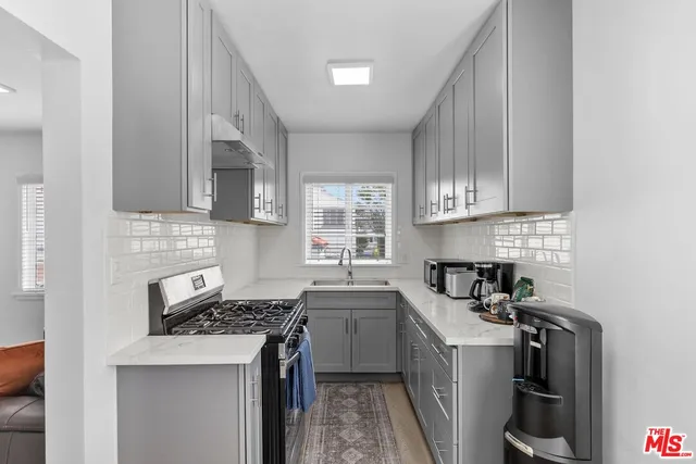 a kitchen with stainless steel appliances a sink stove and cabinets
