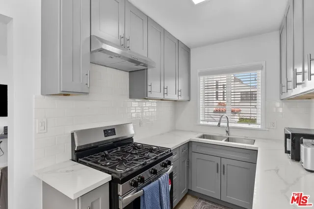 a kitchen with stainless steel appliances a stove a sink and a microwave