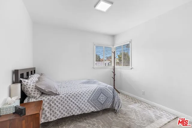 a bedroom with a bed and painting on the wall