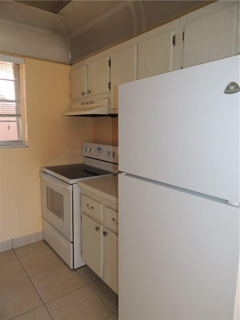 600 Southwest 2nd Avenue, Unit 143 Boca Raton, FL 33432 - Photo 4 of 14 a kitchen with white cabinets and white appliances