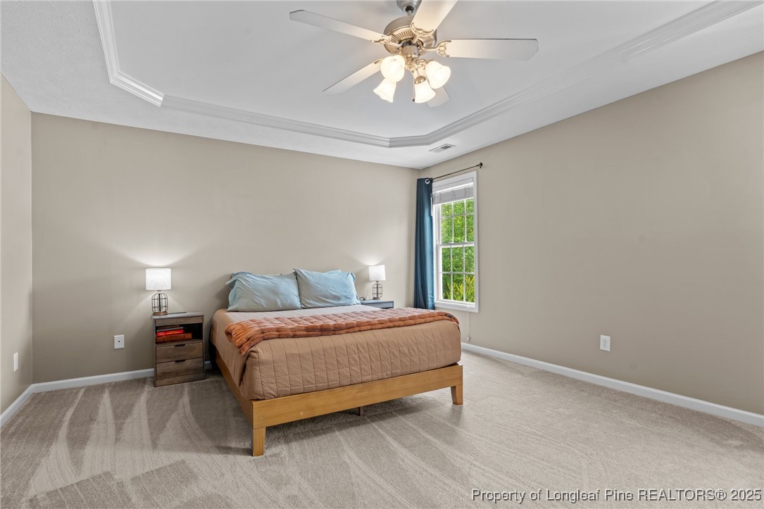 383 Yorkshire Drive Cameron, NC 28326 - Photo 24 of 49 a bedroom with a bed and a chandelier