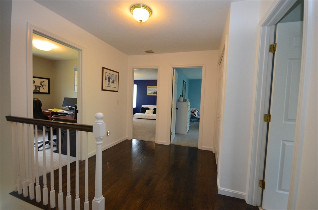 33 Boundary Stone Road Sutton, MA 01590 - Photo 31 of 39 a view of a hallway with wooden floor and a living room
