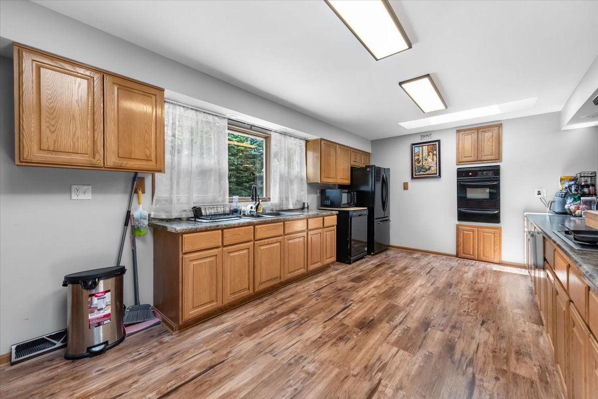 1834 Fischer Road South Beloit, IL 61080 - Photo 13 of 46 a kitchen with granite countertop a stove top oven a sink dishwasher and a refrigerator with wooden floor